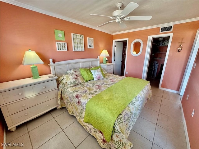 bedroom with crown molding, a walk in closet, light tile patterned flooring, and a closet