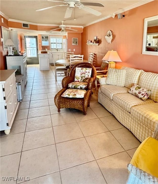 tiled living room with ornamental molding and ceiling fan