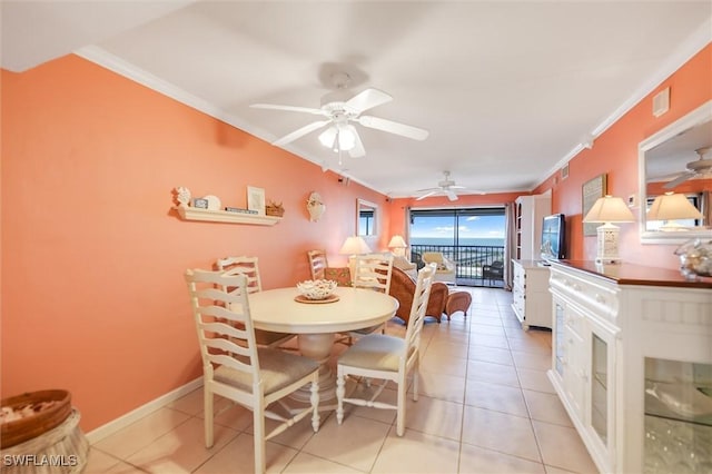 dining area with crown molding, ceiling fan, and light tile patterned floors