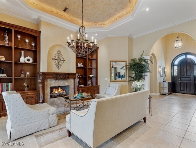 living room featuring crown molding, a fireplace, a raised ceiling, and light tile patterned flooring