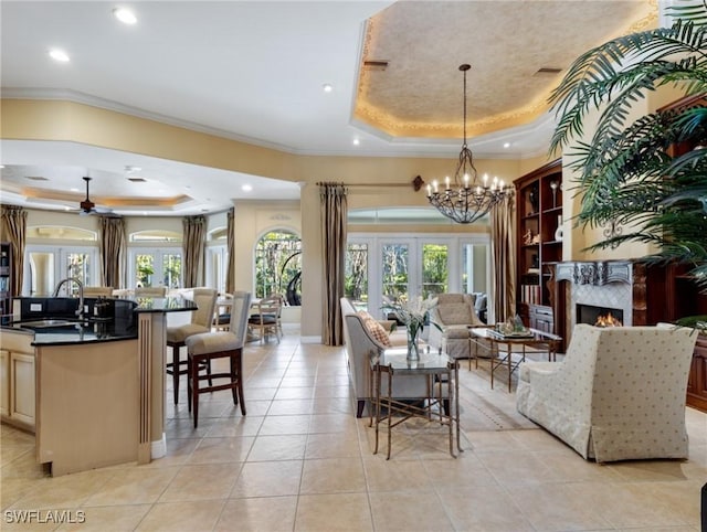 interior space featuring sink, crown molding, light tile patterned flooring, french doors, and a raised ceiling