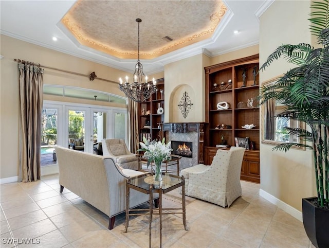 tiled living room with a raised ceiling, crown molding, a high end fireplace, and french doors