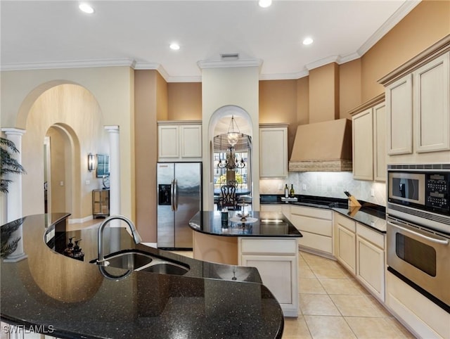 kitchen featuring sink, a kitchen island, stainless steel appliances, tasteful backsplash, and light tile patterned flooring