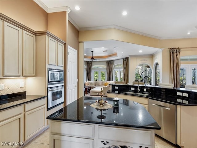 kitchen featuring sink, cream cabinets, stainless steel appliances, and a kitchen island