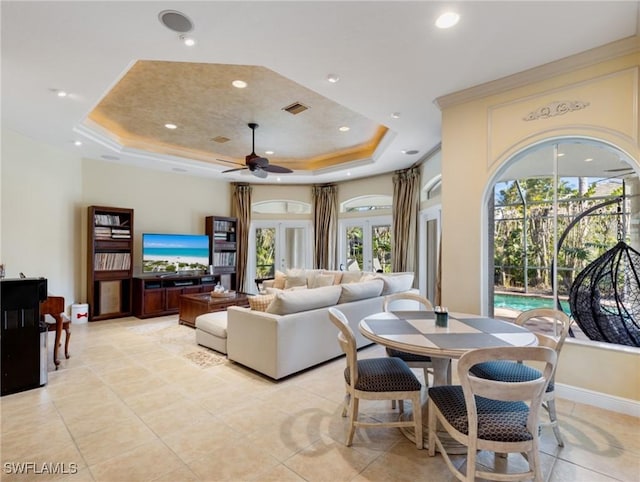 tiled dining space with a tray ceiling, a wealth of natural light, and french doors