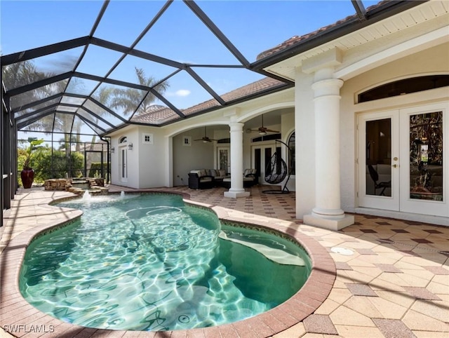 view of swimming pool featuring french doors, a patio area, glass enclosure, ceiling fan, and an outdoor living space