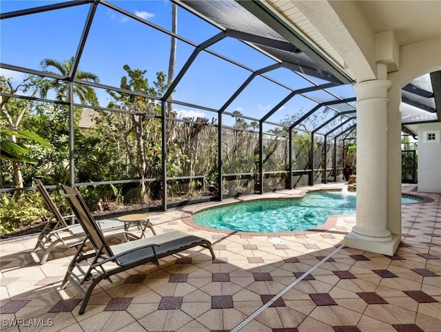 view of swimming pool featuring a patio area and glass enclosure