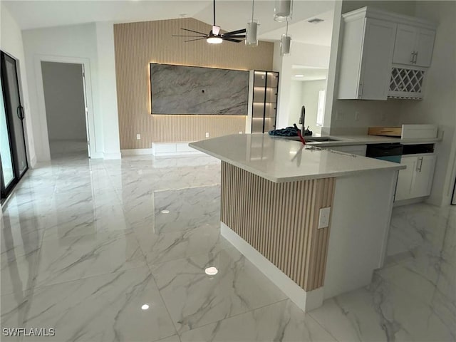 kitchen featuring vaulted ceiling, decorative light fixtures, sink, white cabinets, and kitchen peninsula