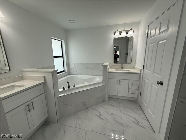 bathroom with vanity and tiled bath