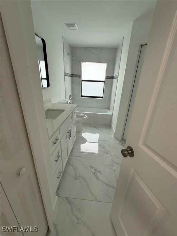 full bathroom with tiled shower / bath, vanity, and toilet