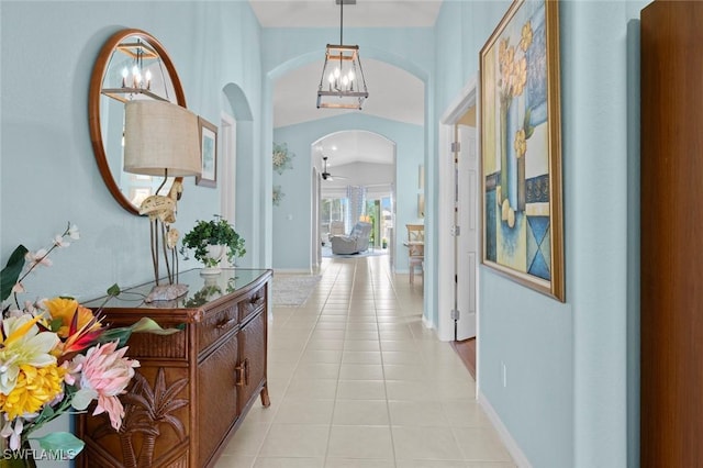 hall featuring light tile patterned flooring and a chandelier