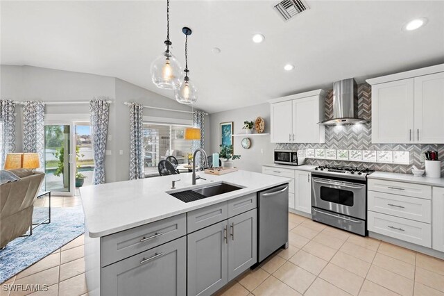 9109 Astonia Way, Estero, FL 33967 - kitchen featuring decorative backsplash, a sink, lofted ceiling, stainless steel appliances, and wall chimney exhaust hood