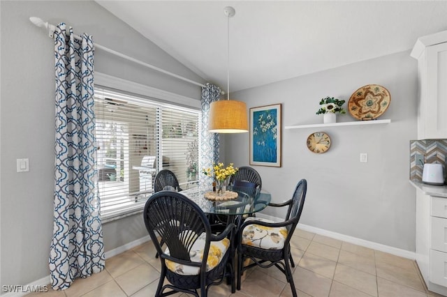 dining room featuring vaulted ceiling and light tile patterned floors