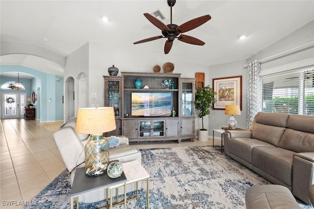 tiled living room featuring ceiling fan and vaulted ceiling