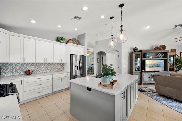 kitchen with range, a center island, stainless steel fridge with ice dispenser, pendant lighting, and white cabinets