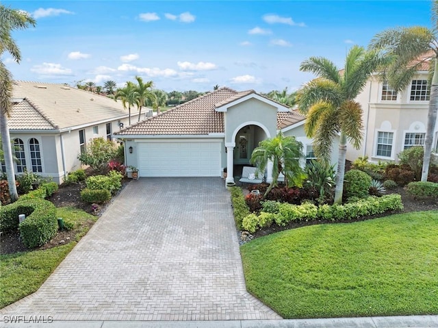 mediterranean / spanish house featuring a garage and a front yard