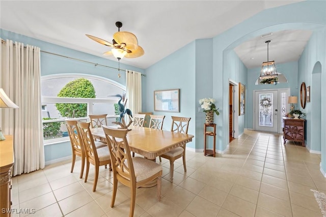 tiled dining area featuring lofted ceiling, plenty of natural light, and ceiling fan with notable chandelier