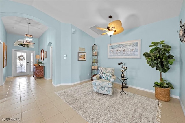 sitting room with lofted ceiling, light tile patterned floors, and ceiling fan with notable chandelier