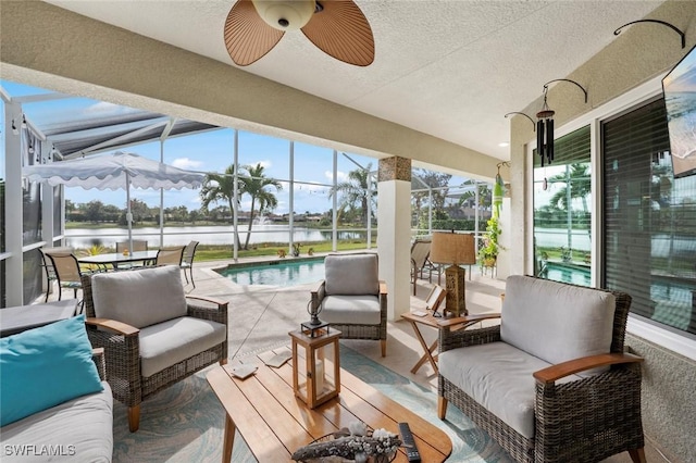 sunroom with a water view, plenty of natural light, and ceiling fan