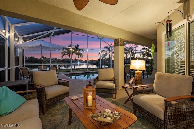 exterior space featuring a lanai, an outdoor hangout area, ceiling fan, and a water view