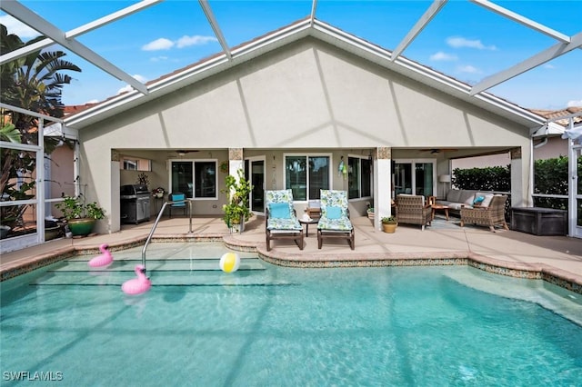 view of pool with a patio, outdoor lounge area, ceiling fan, and a lanai