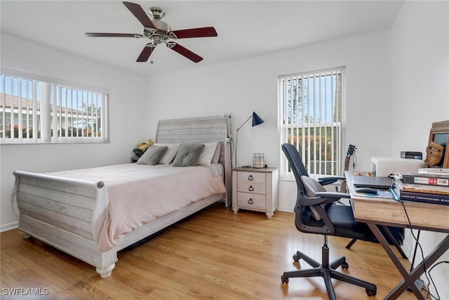 bedroom featuring multiple windows, ceiling fan, and light wood-type flooring