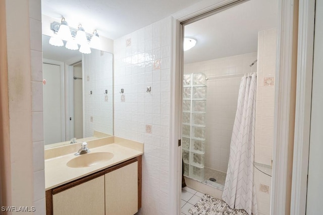 bathroom with tile patterned flooring, vanity, tile walls, and a shower with shower curtain