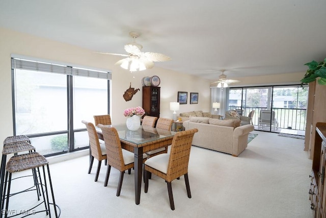 dining space featuring light colored carpet and ceiling fan