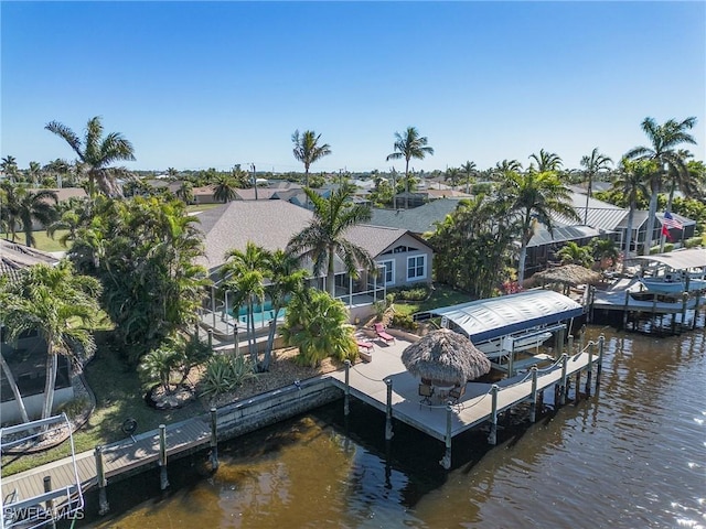 dock area featuring a water view, boat lift, and a residential view