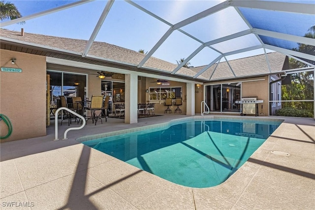 view of pool with ceiling fan, a lanai, a patio, and a grill