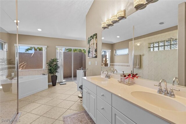 bathroom featuring a washtub, tile patterned flooring, vanity, and a wealth of natural light