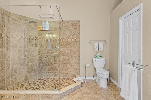 bathroom featuring a tile shower, tile patterned flooring, and toilet