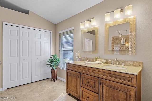 bathroom featuring vaulted ceiling, tile patterned flooring, and vanity