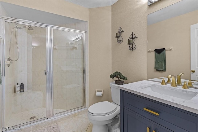 bathroom with tile patterned floors, toilet, vanity, and an enclosed shower