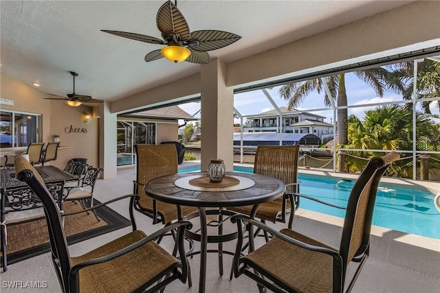 sunroom with lofted ceiling, a swimming pool, and ceiling fan