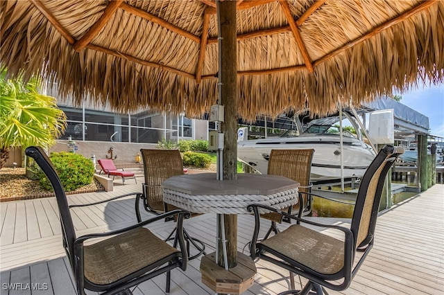 deck with a dock, glass enclosure, and a gazebo