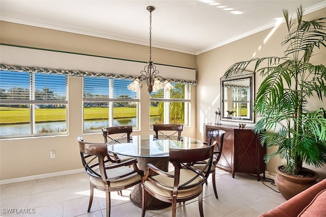 dining room with a notable chandelier, crown molding, light tile patterned floors, and a water view