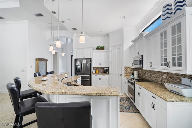 kitchen with appliances with stainless steel finishes, a breakfast bar, white cabinetry, backsplash, and hanging light fixtures