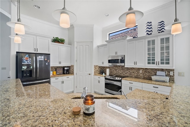 kitchen with pendant lighting, stainless steel appliances, and white cabinets