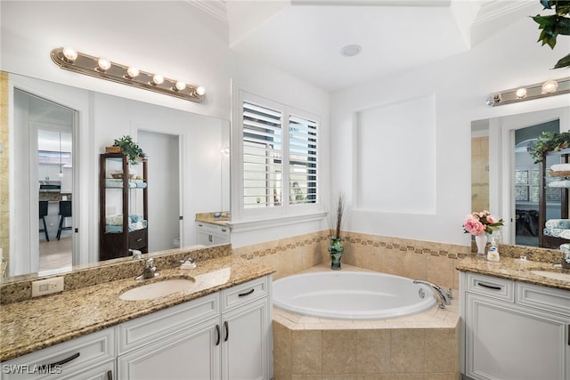 bathroom featuring a relaxing tiled tub and vanity