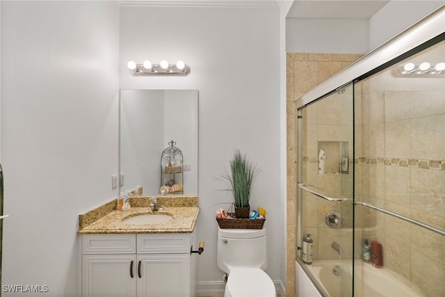 full bathroom with vanity, bath / shower combo with glass door, and toilet