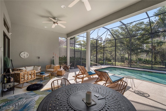 view of swimming pool with an outdoor hangout area, a patio, ceiling fan, and glass enclosure