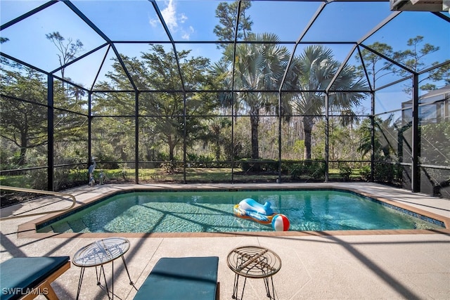 view of swimming pool featuring a lanai and a patio area