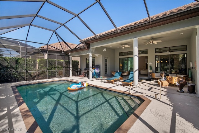 view of swimming pool with ceiling fan, a lanai, and a patio