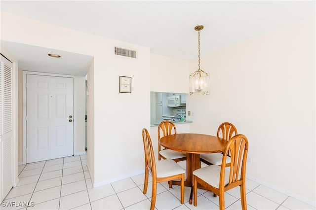 dining room featuring a notable chandelier and light tile patterned floors