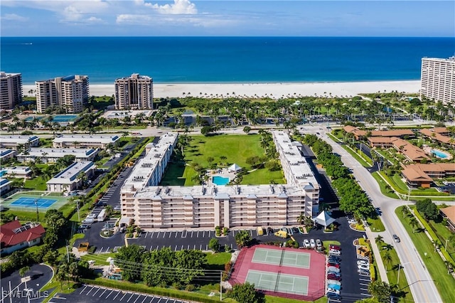 drone / aerial view featuring a beach view and a water view