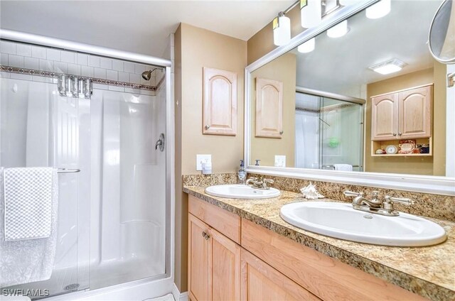 bathroom with vanity and a shower with door