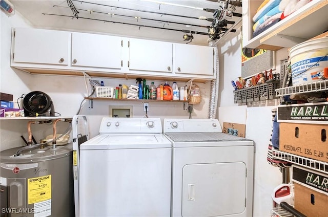 laundry area featuring water heater, washing machine and dryer, and cabinets