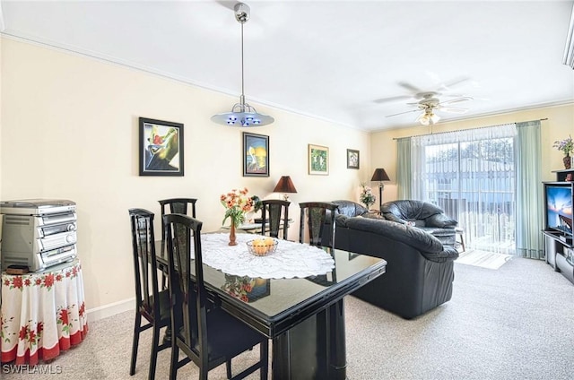 dining room featuring crown molding, light colored carpet, and ceiling fan