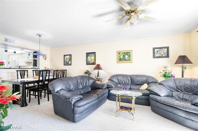 carpeted living room with ornamental molding and ceiling fan